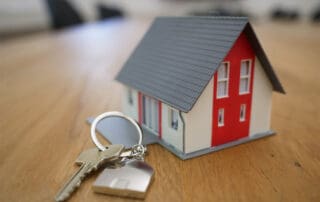 Small house with a big lock and key on a table